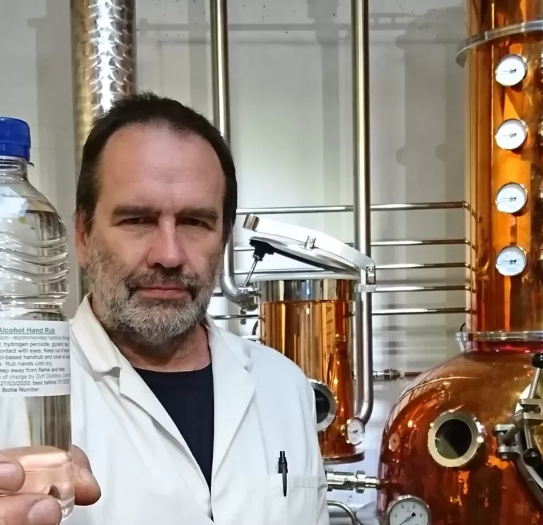 Man holding up a bottle at a distillery 