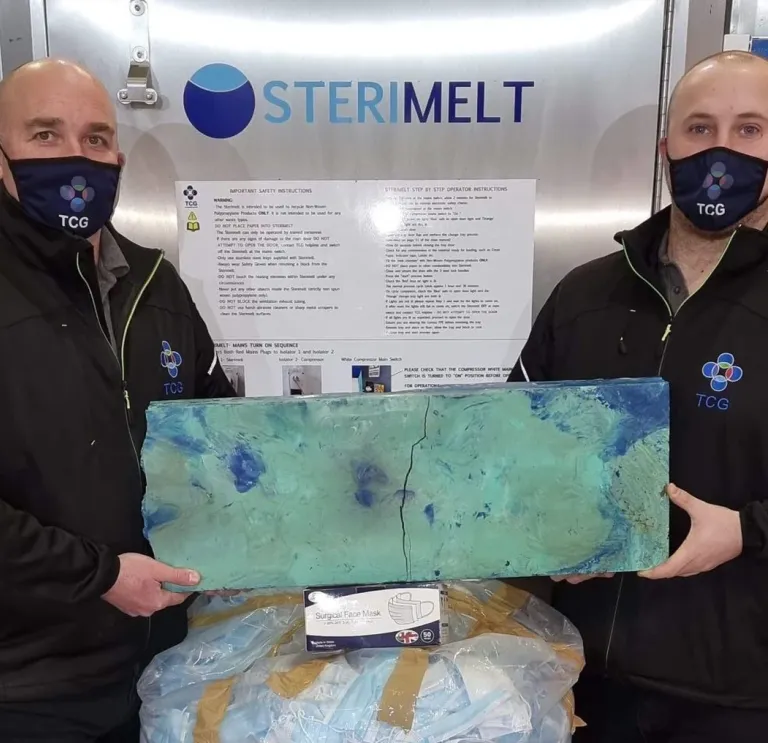 Two men holding up recycled material