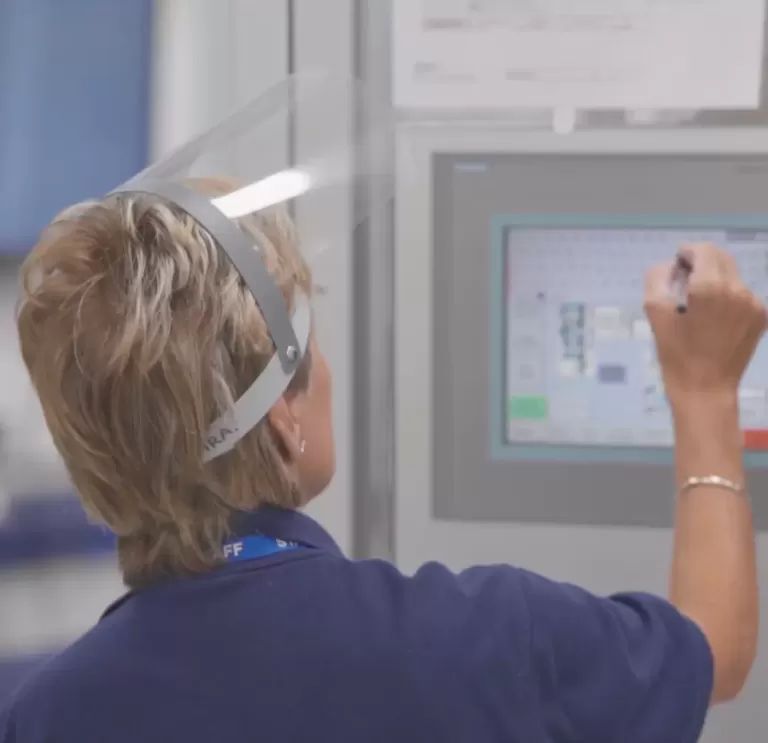 Lady with face visor operating a touch screen