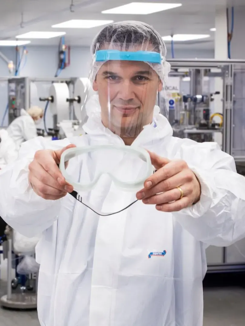 Man holding up safety googles