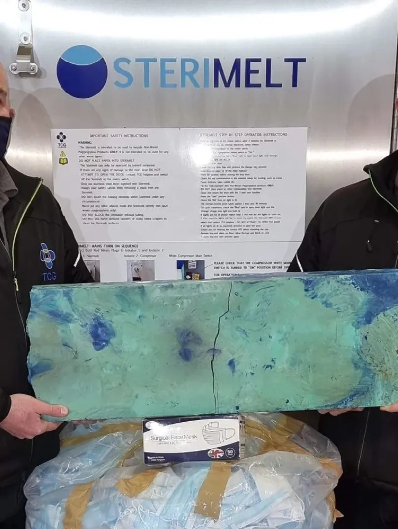 Two men holding up recycled material