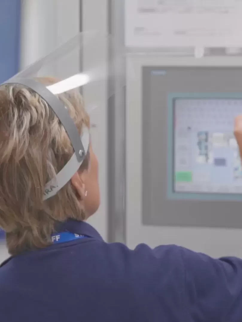 Lady with face visor operating a touch screen