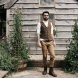 Man if font of a wooden building