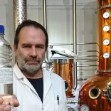 Man holding up a bottle at a distillery 