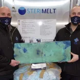Two men holding up recycled material
