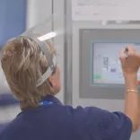 Lady with face visor operating a touch screen