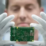 Man holding up a circuit board